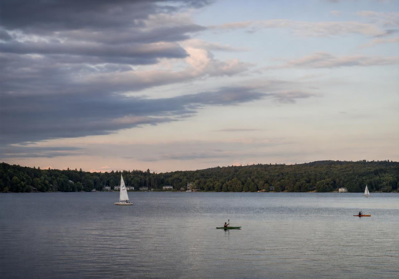 Sailboats and kayaks on the lake at golden hour